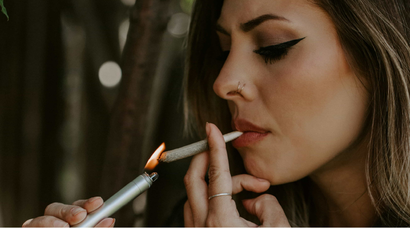 Woman lighting up a THCA joint. 